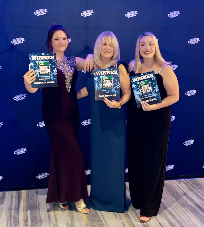 Three women holding 2026 Community’s Choice Awards winner certificates for Oasis Salon & Spa